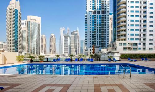 a swimming pool in a city with tall buildings at Khayali Marina Holiday Homes Dubai Marina JBR in Dubai