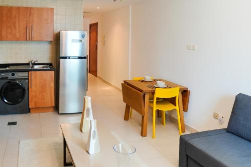 a kitchen and living room with a table and a refrigerator at Khayali Marina Holiday Homes Dubai Marina JBR in Dubai