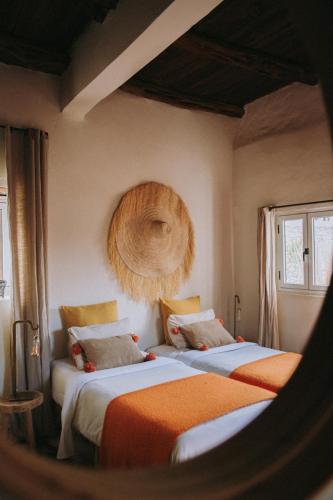 two beds in a room with two windows at Les jardins de Silona, piscine chauffée in Essaouira