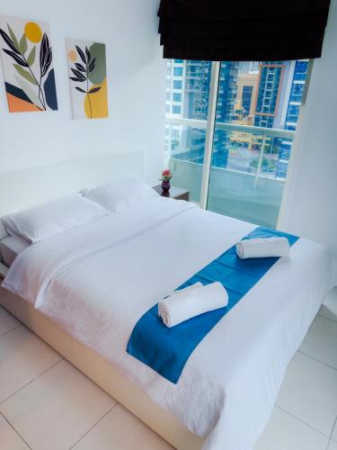 a large white bed with two pillows on it at Khayali Marina Holiday Homes Dubai Marina JBR in Dubai