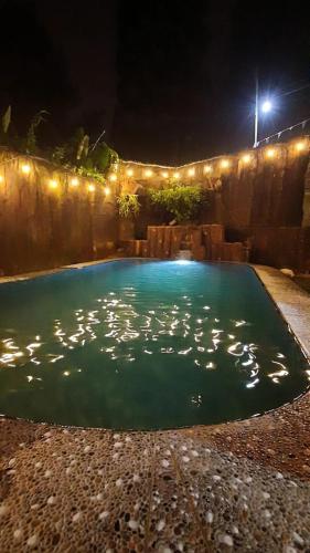 a swimming pool at night with lights on it at Villa Montana Batulayang in Sampal 2
