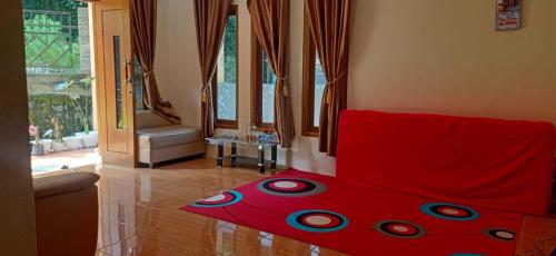 een rood bed in een kamer met ramen bij Villa Montana Batulayang in Sampal 2