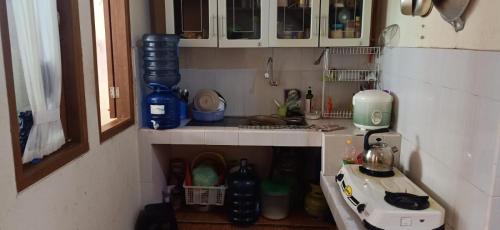 een kleine keuken met een spoelbak en een fornuis bij Villa Montana Batulayang in Sampal 2