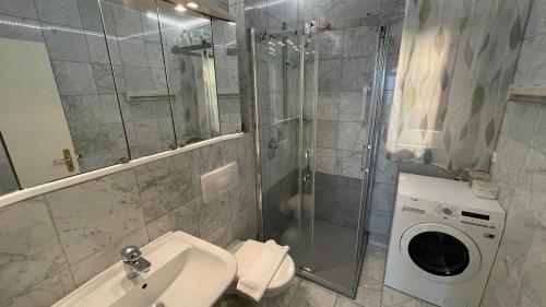 a bathroom with a sink and a washing machine at Penthouse Ostseepanorama in Pelzerhaken