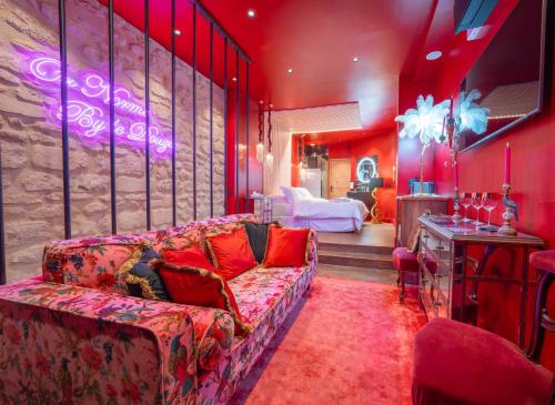 a living room with a couch and a table at Suite Jacuzzi & Sauna privatifs - Paris - Or Norme By Le Douze in Paris
