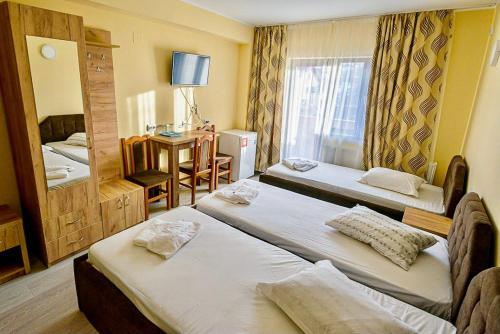 a hotel room with two beds and a mirror at Pensiunea Domneasca in Piteşti
