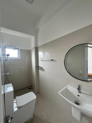 a white bathroom with a sink and a mirror at City Hotel Thalawathugoda in Talawatugoda