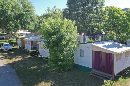 a row of mobile homes parked in a yard at ZEcamping 4 étoiles dog friendly bien-être restaurant et soirées animées in Foix