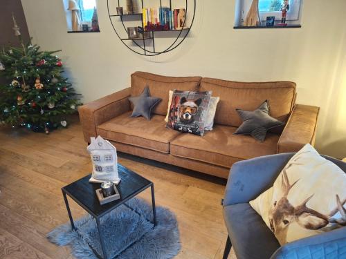 a living room with a couch and a christmas tree at B&B Caprice d'Epices in Francorchamps
