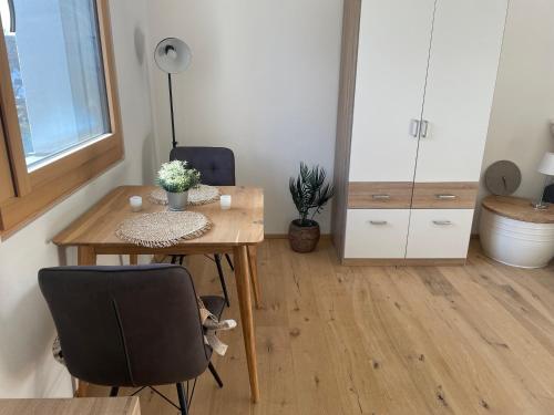 Zimmer mit einem Tisch, 2 Stühlen und einem Schreibtisch in der Unterkunft Modernes & gemütliches Apartment in Zentrumsnähe in Kempten