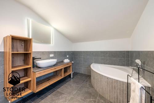 a bathroom with a bath tub and a sink at StoderLodge - Alpine Garden Residence - by myNests in Gröbming