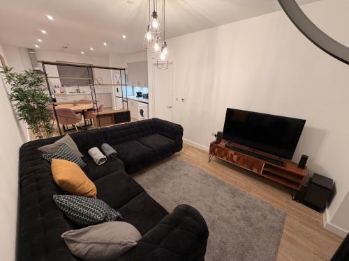a living room with a couch and a flat screen tv at HRF Barking Apartments in Barking