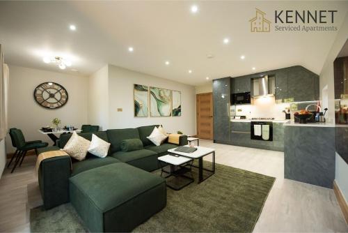 a living room with a green couch and a kitchen at Oak Lodge in Reading