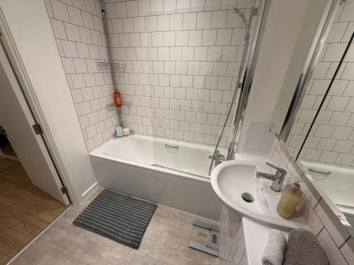 a bathroom with a tub and a sink and a bath tub at HRF Barking Apartments in Barking