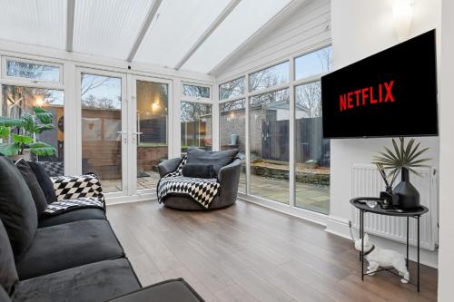 a living room with a tv and a couch and chairs at Lovely 4b Stay- Ideal for Contractors & Families in Bury