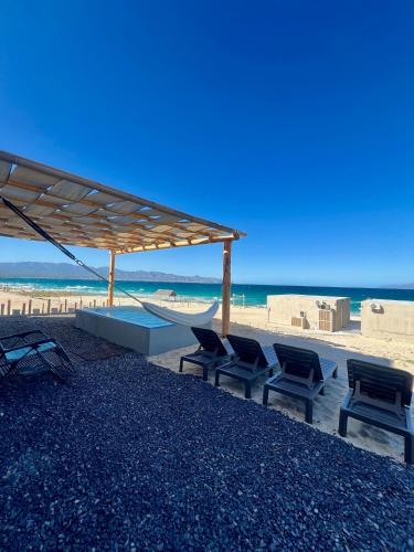 a group of chairs and a hammock on a beach at Grand Ocean View Suite with Private Pool in La Paz