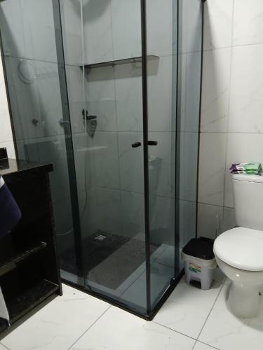 a glass shower in a bathroom with a toilet at Casa aconchegante e familiar em Matinhos in Matinhos