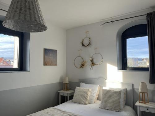 ein Schlafzimmer mit einem Bett mit zwei Uhren an der Wand in der Unterkunft La Poterne l Chambres d'hôtes à Epernay in Épernay