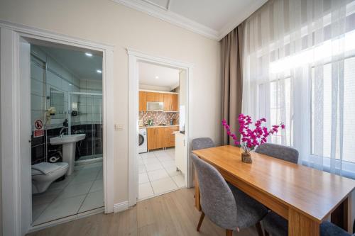 a dining room with a table and a bathroom at Feyza Apart in Istanbul