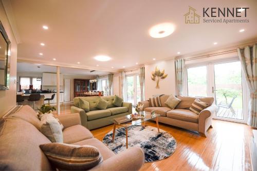 a large living room with couches and a table at Palm Cottage in Reading