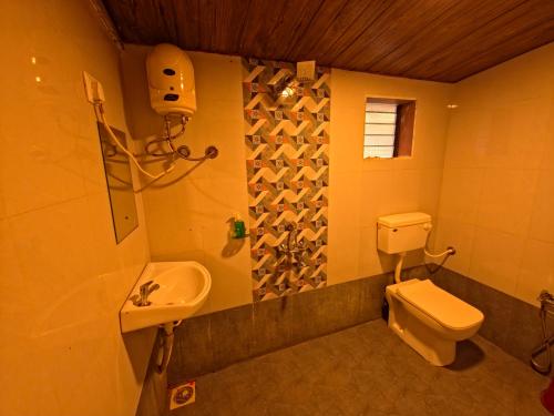 a bathroom with a toilet and a sink at Coastal Home in Diveagar