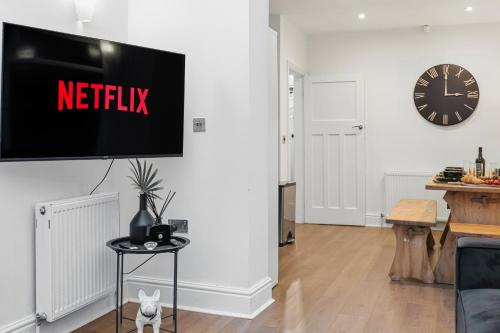 a living room with a tv on a wall at Lovely 4b Stay- Ideal for Contractors & Families in Bury