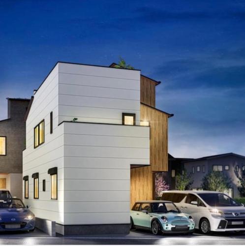 two cars parked in front of a white building at Tokyo Hoshino House 1Floor in Tokyo