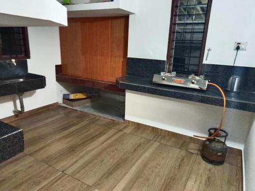 een keuken met een houten vloer en een aanrecht met een slang bij Holidays Homestay Vagamon in Vagamon