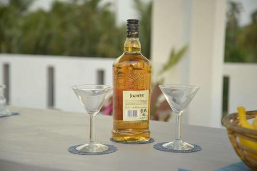 une bouteille de whisky et deux verres sur une table dans l'établissement Blue Horizon Villa - Rathgama, à Ratgama Hegoda