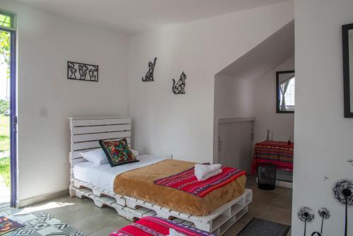 a bedroom with a bed in a white room at Finca Turística en Quindío cerca a Panaca in Quimbaya