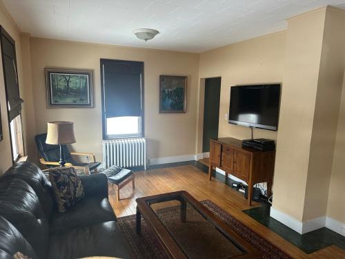 un soggiorno con divano e TV a schermo piatto di Charming Four Bedroom House a Tannersville