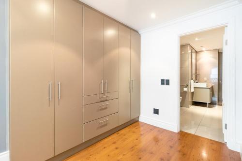a large closet with white cabinets in a bathroom at Cape Royale Elegance & Comfort in Cape Town