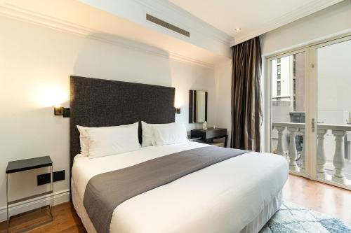 a bedroom with a large bed and a large window at Cape Royale Elegance & Comfort in Cape Town