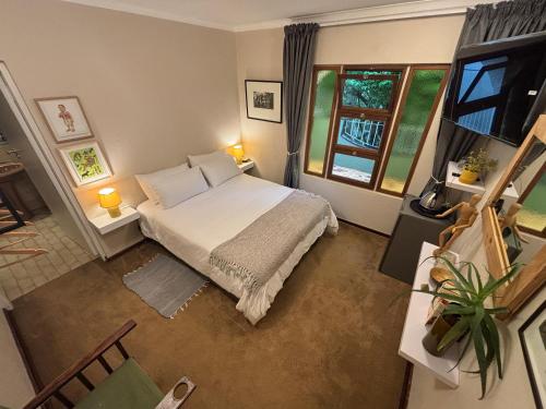 a small bedroom with a bed and a window at La Casa Blanca in Johannesburg