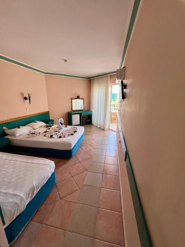 a hotel room with two beds and a bathroom at KLEOPATRA SUNLIGHT HOTEL in Alanya
