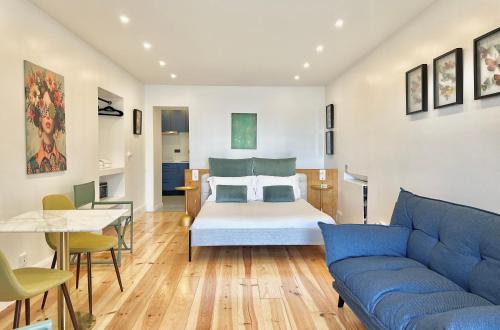 ein Wohnzimmer mit einem Bett und einer blauen Couch in der Unterkunft Espada Preta Apartments in Câmara de Lobos