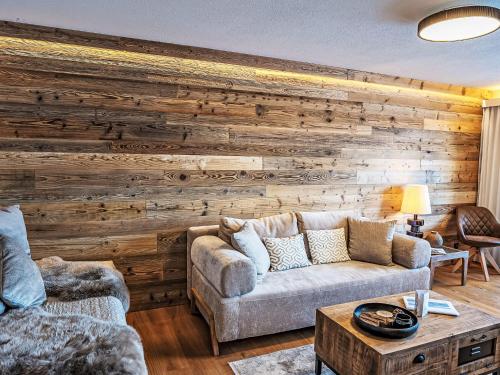 een woonkamer met een houten accentmuur bij Apartment Chesa Fleury by Interhome in St. Moritz