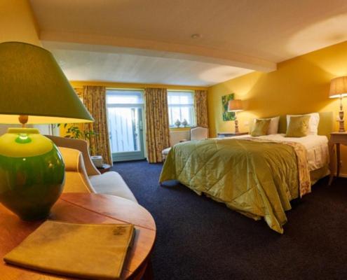 una camera d'albergo con letto e tavolo con lampada di Bed and Breakfast Reestdal a Meppel