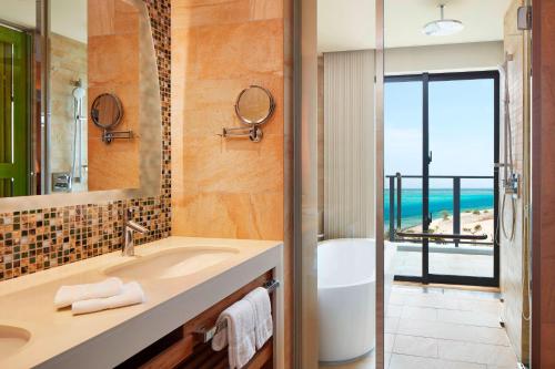 a bathroom with a sink and a view of the ocean at Sheraton Okinawa Sunmarina Resort in Onna