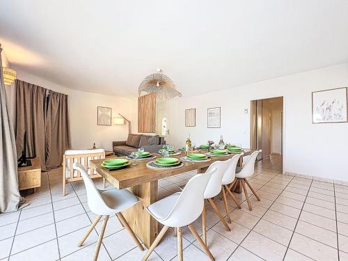 ein Esszimmer mit einem Holztisch und weißen Stühlen in der Unterkunft Villa Orée des Salines by Interhome in Le Grau-du-Roi