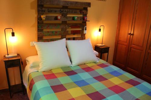 1 dormitorio con 1 cama colorida y 2 lámparas en Apartamento La Venencia, en Jerez de la Frontera