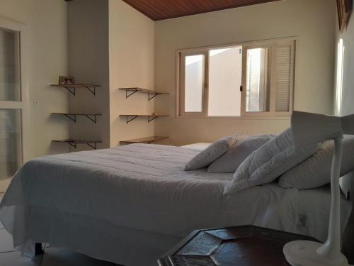 a bedroom with a large bed and a window at Hostel Peró Cabo Frio in Cabo Frio