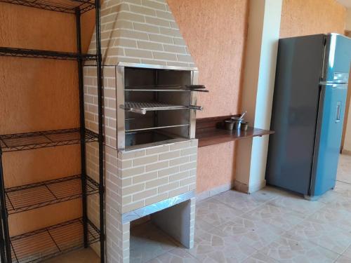 a brick oven in a kitchen next to a refrigerator at Hostel Peró Cabo Frio in Cabo Frio