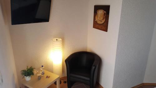 a black chair next to a table with a lamp at Hotel Exquisite in Bobenheim am Berg