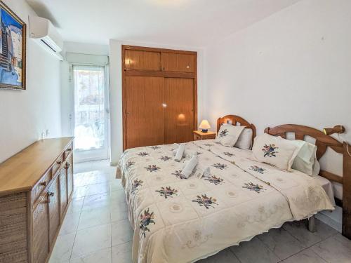 ein Schlafzimmer mit einem großen Bett und einer Holzkommode in der Unterkunft Apartment Celio I by Interhome in Albir