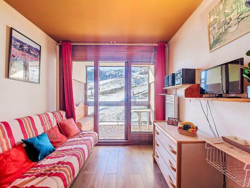 een woonkamer met een bank en een televisie bij Studio Cosmos-7 by Interhome in Le Corbier