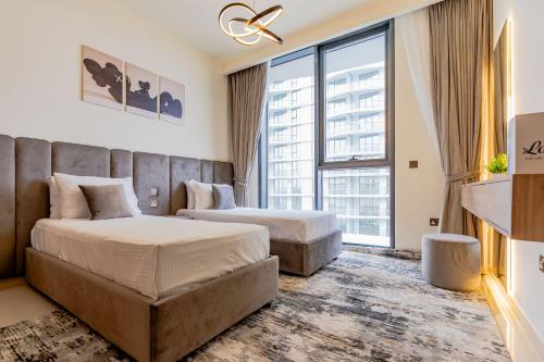 a hotel room with two beds and a large window at Nasma Luxury stays- Sophisticated Interior near Hayat Beach in Ras al Khaimah