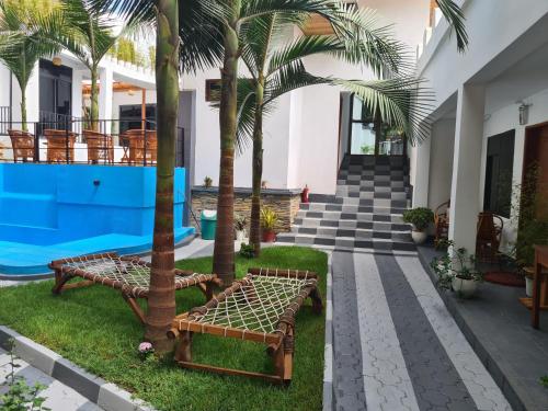 een patio met twee banken en palmbomen voor een huis bij Didas Villa Stay Deluxe in Arusha