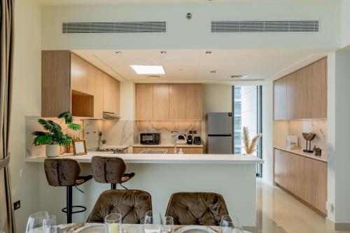 a kitchen with a table and chairs in a room at Nasma Luxury stays- Sophisticated Interior near Hayat Beach in Ras al Khaimah