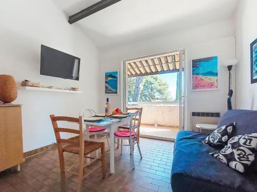 un salon avec une table et un canapé bleu dans l'établissement Studio Les Hauts du Port-1 by Interhome, à Saint-Cyr-sur-Mer